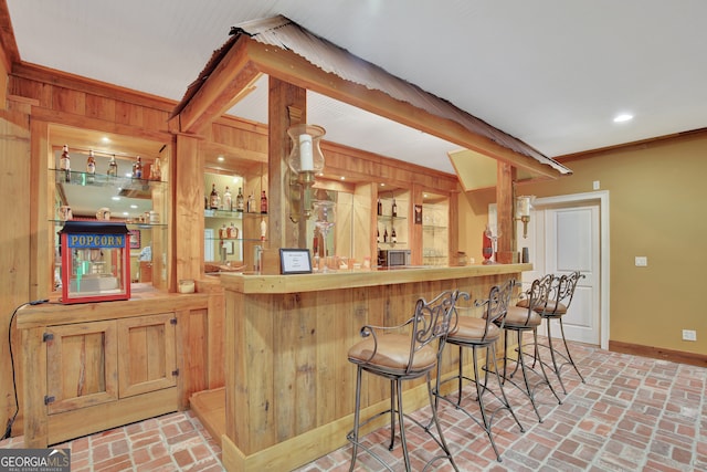 bar with crown molding and wood walls