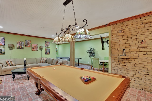 playroom featuring pool table, crown molding, and brick wall