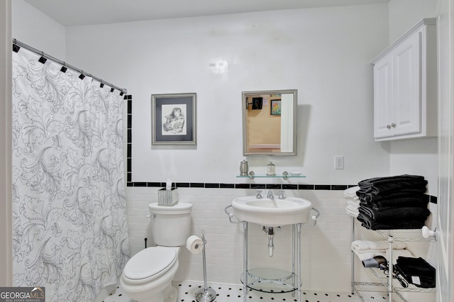 bathroom featuring tile walls, curtained shower, toilet, and tile patterned flooring