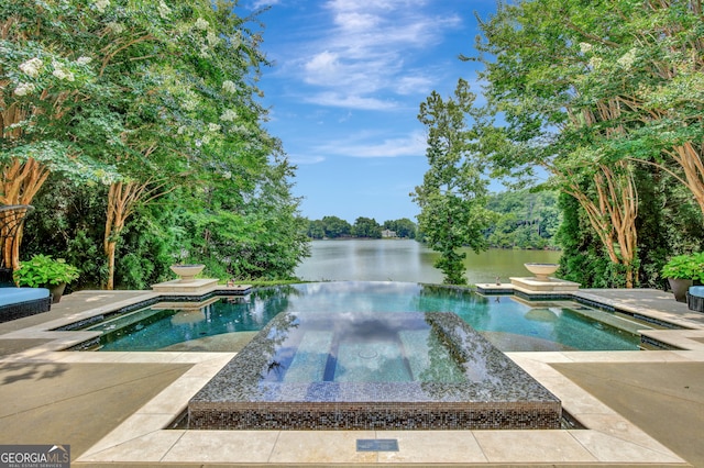 view of swimming pool featuring a patio, an in ground hot tub, and a water view