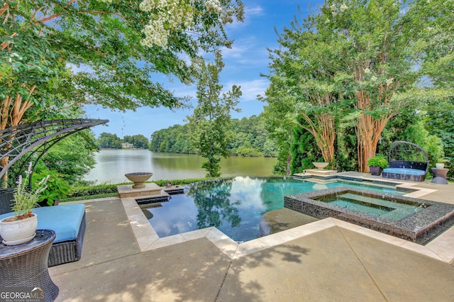 view of swimming pool with a patio area, an in ground hot tub, and a water view