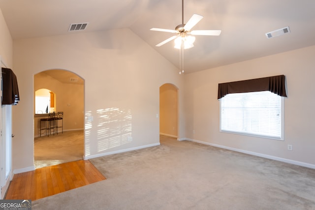 interior space featuring light colored carpet, high vaulted ceiling, and ceiling fan