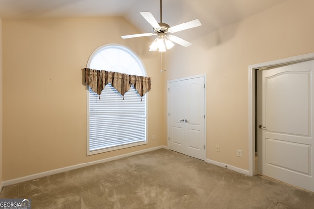 carpeted empty room with ceiling fan and lofted ceiling