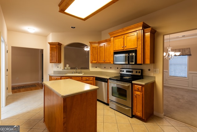 kitchen featuring sink, stainless steel appliances, light tile patterned floors, a chandelier, and a kitchen island