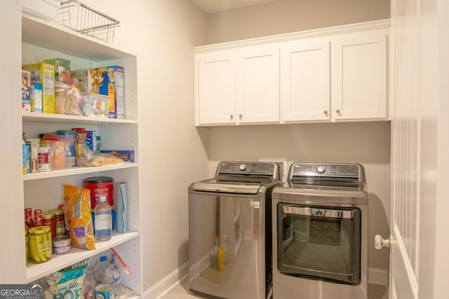 washroom with cabinets and washer and clothes dryer