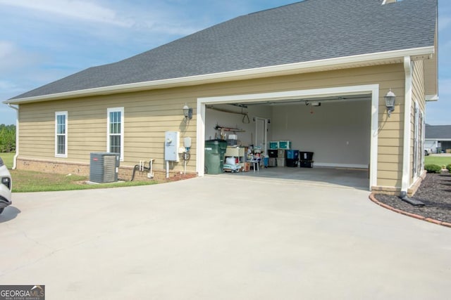 back of house featuring a garage and cooling unit