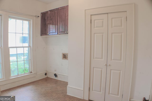 laundry area featuring light parquet floors, hookup for an electric dryer, washer hookup, and cabinets