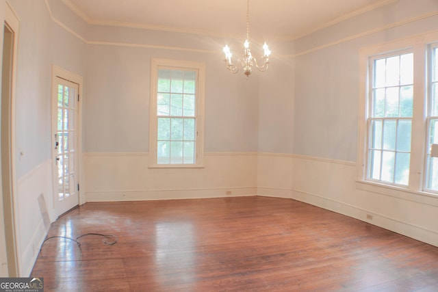 empty room with hardwood / wood-style flooring, a healthy amount of sunlight, and crown molding