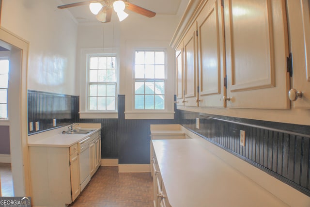 kitchen with parquet floors, white dishwasher, sink, and cream cabinetry