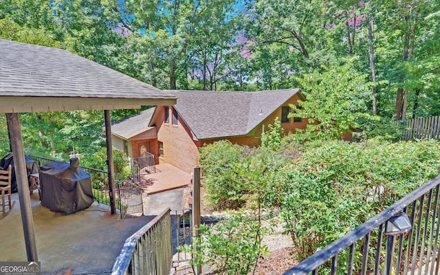 view of home's exterior with roof with shingles and a balcony