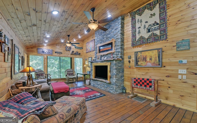 living room with wood ceiling, ceiling fan, hardwood / wood-style floors, wooden walls, and a fireplace