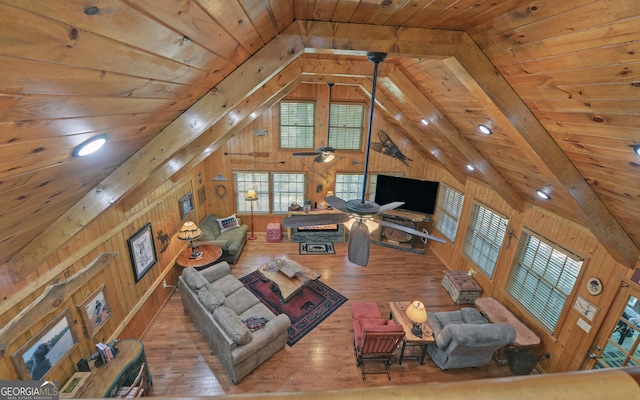 living area with hardwood / wood-style floors, vaulted ceiling with beams, wooden walls, and wooden ceiling