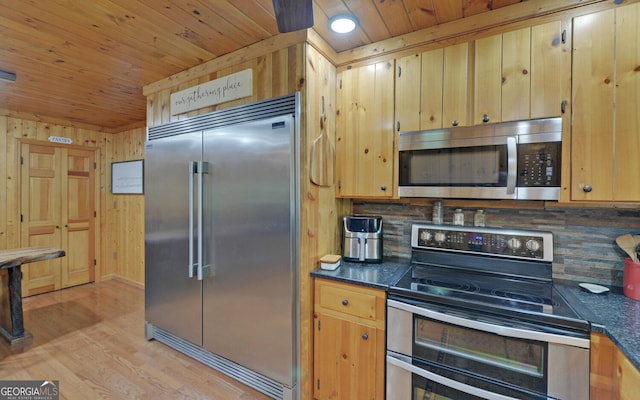 kitchen with light wood finished floors, backsplash, dark countertops, wood ceiling, and appliances with stainless steel finishes