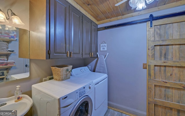 washroom with cabinets, washing machine and clothes dryer, ceiling fan, wood ceiling, and a barn door