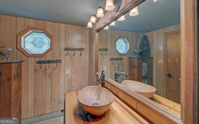 bathroom with vanity and wooden walls