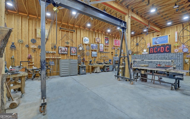 garage with a workshop area and wooden walls