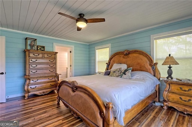 bedroom with ceiling fan, dark hardwood / wood-style flooring, and multiple windows