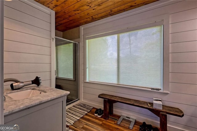 bathroom featuring vanity, wood ceiling, wood walls, and hardwood / wood-style floors