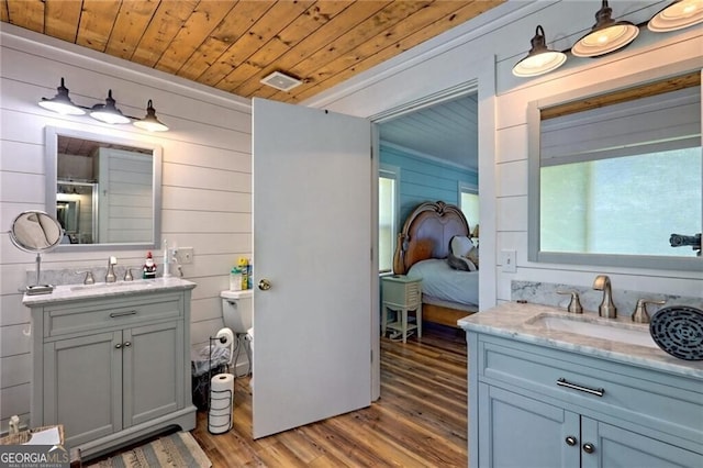 bathroom with hardwood / wood-style flooring, vanity, wood walls, and wood ceiling