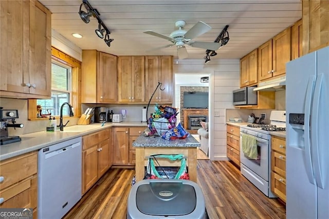 kitchen featuring sink, white appliances, dark hardwood / wood-style floors, and a kitchen island