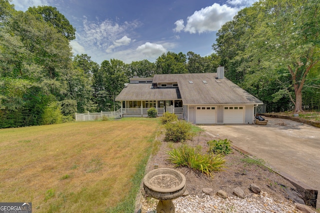 view of front of home with a garage, a porch, and a front lawn