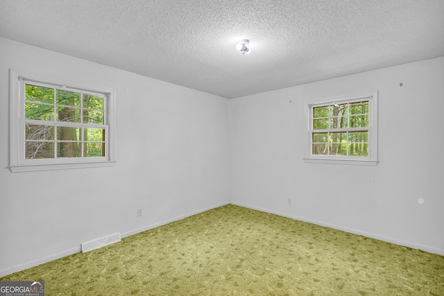 carpeted spare room featuring a textured ceiling