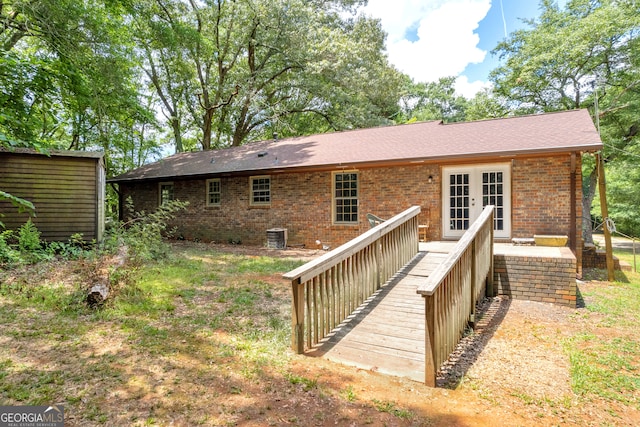 back of property featuring central air condition unit, a wooden deck, and french doors