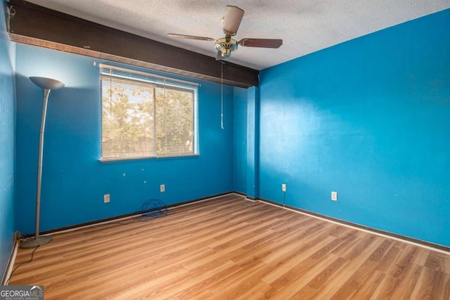 unfurnished room with ceiling fan, hardwood / wood-style floors, and a textured ceiling