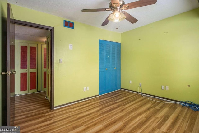 unfurnished room featuring ceiling fan, wood-type flooring, and a textured ceiling