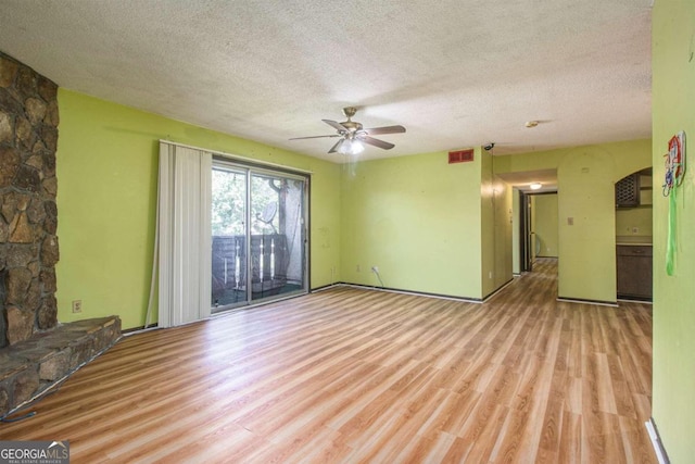 unfurnished living room featuring light hardwood / wood-style floors, a textured ceiling, and a fireplace