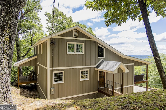 view of front facade featuring board and batten siding and roof with shingles