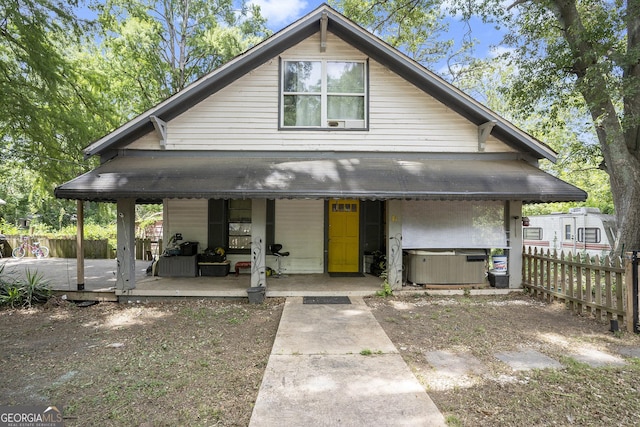 view of front facade featuring covered porch and a hot tub