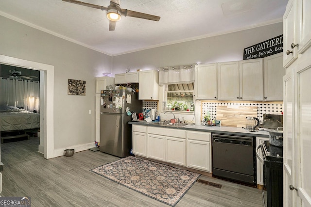 kitchen featuring stainless steel refrigerator, sink, black dishwasher, backsplash, and wood-type flooring