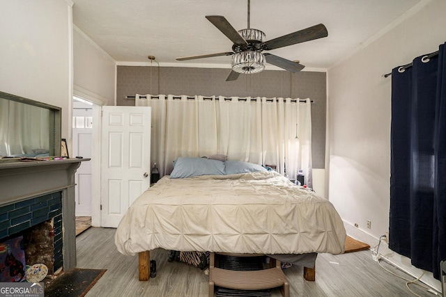 bedroom featuring wood-type flooring, ceiling fan, and ornamental molding