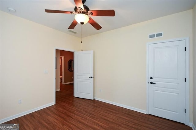 unfurnished room with ceiling fan and dark hardwood / wood-style flooring