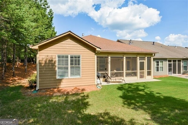 back of property with a lawn, a patio, and a sunroom