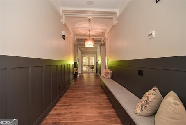 corridor with beam ceiling, crown molding, and hardwood / wood-style flooring