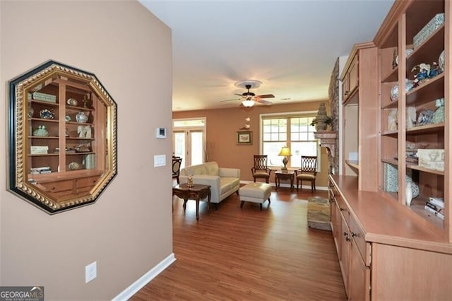 living room with ceiling fan and dark hardwood / wood-style floors