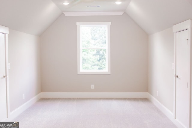 additional living space with vaulted ceiling and light carpet