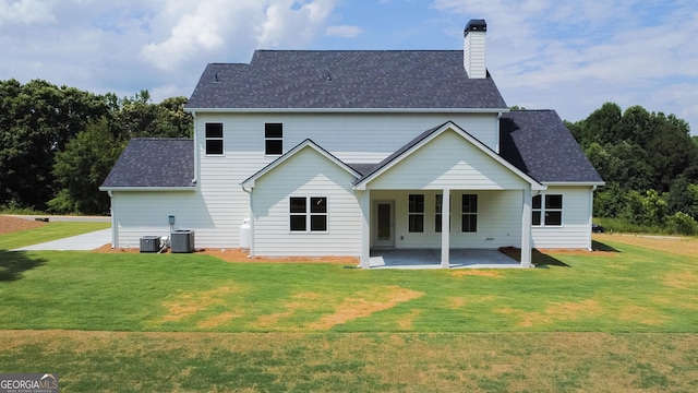 rear view of house featuring a lawn, central AC, and a patio