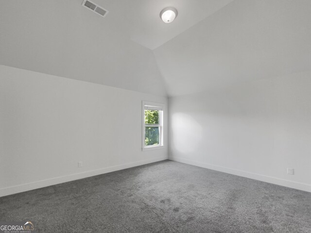 empty room featuring lofted ceiling and carpet