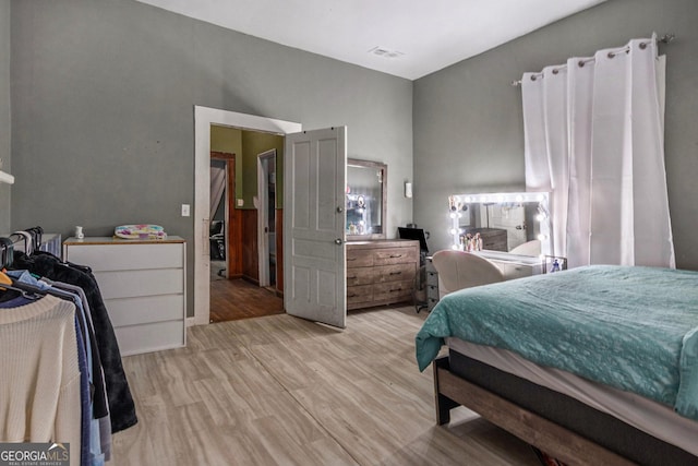 bedroom featuring lofted ceiling and light wood-type flooring