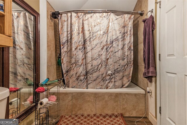 bathroom with shower / tub combo and toilet