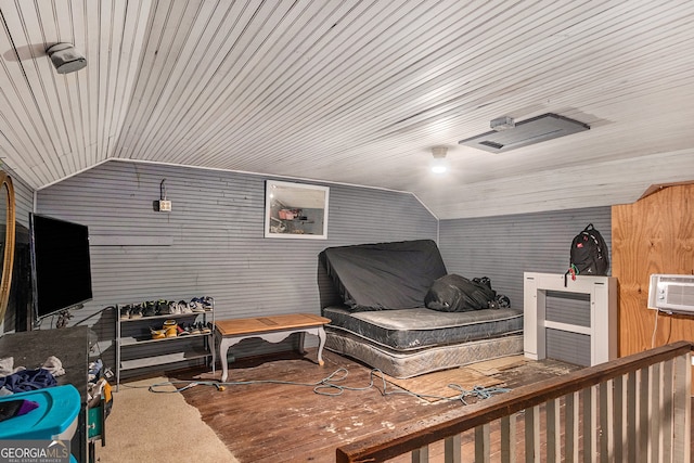 bedroom with wood walls, hardwood / wood-style flooring, and vaulted ceiling