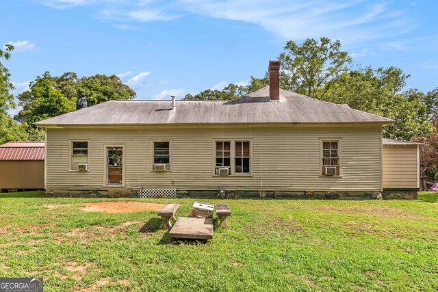 rear view of house featuring a yard