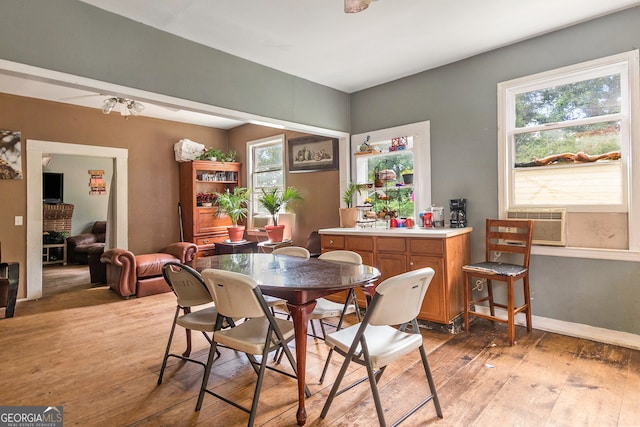 dining space with hardwood / wood-style floors and cooling unit