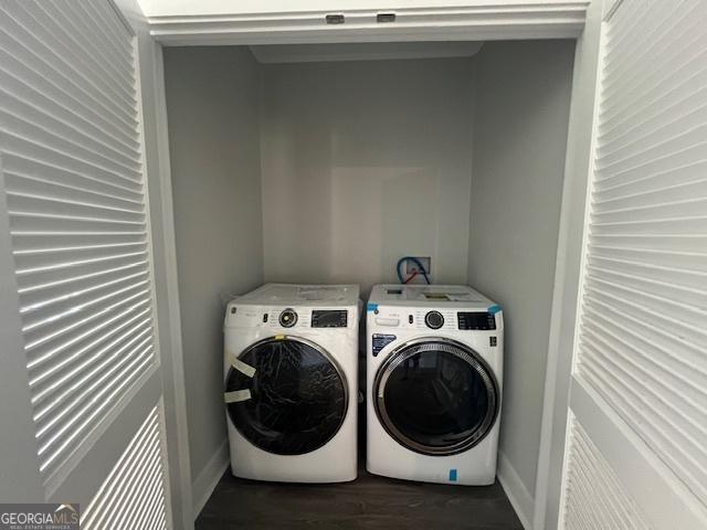 clothes washing area featuring separate washer and dryer and dark wood-type flooring