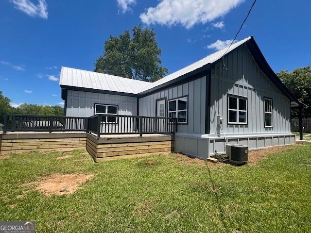 back of house featuring a yard, central AC unit, and a deck