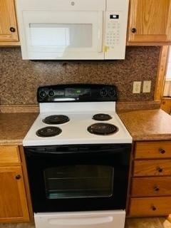 kitchen with electric stove and tasteful backsplash