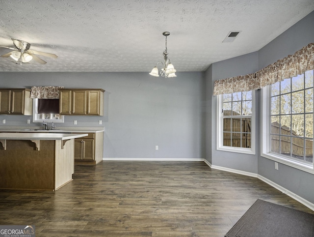 1301 Crosswind Pl, Mcdonough, GA 30252 - kitchen featuring ceiling fan with notable chandelier, light countertops, a kitchen breakfast bar, and dark wood finished floors